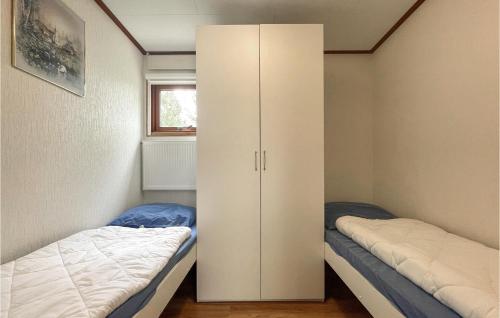 伊皮2 Bedroom Lovely stacaravan In Epe的一间卧室配有两张床和白色橱柜
