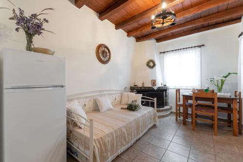 纳克索乔拉Ktima Dimitrios的一间卧室配有一张床铺、一张桌子和一台冰箱