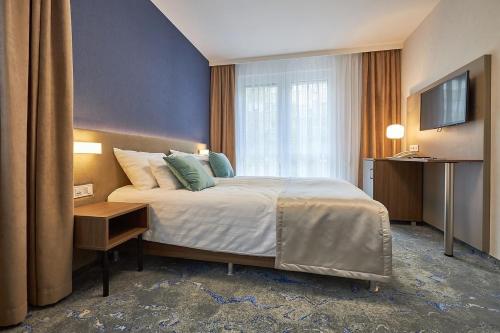 豪伊杜索博斯洛Hotel Crystal的酒店客房,配有床和电视
