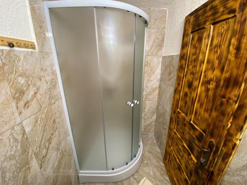 阿尔巴克Casa Teodora的浴室设有玻璃淋浴间和木门