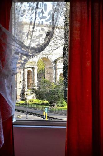 那不勒斯Central Station B&B Naples的窗户配有红色窗帘,享有建筑的景致