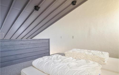 布罗斯特Feriehotal Tranum Klit的天花板客房内的一张未铺床