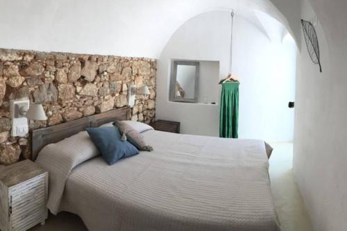 维科德尔加尔加诺Casa San Valentino的一间卧室设有一张大床和石墙