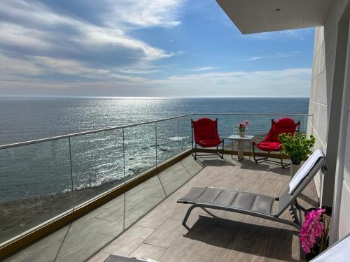 科斯蒂内什蒂Alessio Hotel Residence的阳台配有两把椅子和一张桌子,享有海景。