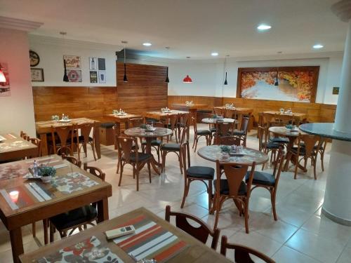 乌穆阿拉马ROMA'S HOTEL的餐厅内带桌椅的用餐室