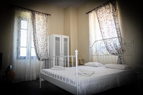 Sálakos尼姆费旅馆的卧室配有白色的床和2扇窗户。