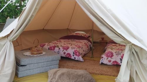 Domek na wsi的帆布帐篷内一间卧室,配有两张床