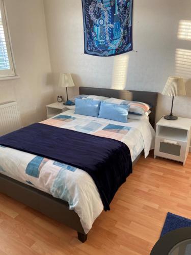 伦敦Streatham Common Bed & Breakfast的一间卧室配有一张带蓝色枕头的大床