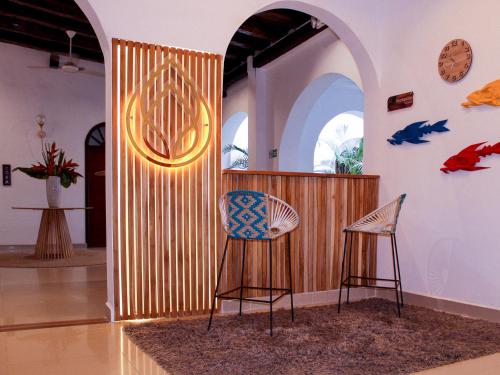 卡塔赫纳Hotel Casa Agustina的一间设有两把椅子和木墙的房间