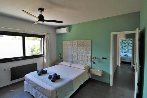 圣何塞德萨塔莱阿Casa moderna a 300 metros de la playa.的一间卧室配有一张床和吊扇