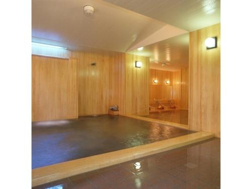 涩川市Ikaho Onsen Sanyo Hotel - Vacation STAY 26406v的一间大型空房间,设有带有木墙的健身房