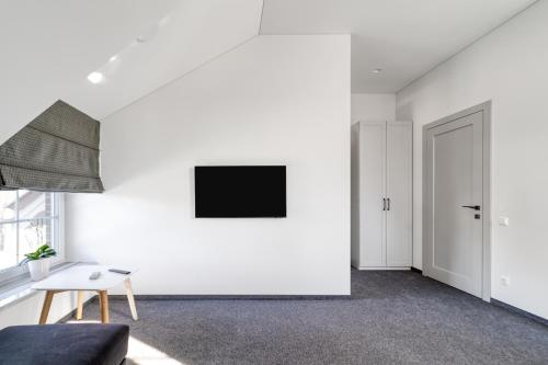 卡尔克尔Karklės Oazė的客厅配有沙发和墙上的电视