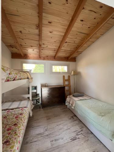 圣卡洛斯-德巴里洛切Casa de Campo La Chacra的一间卧室设有两张双层床和木制天花板。