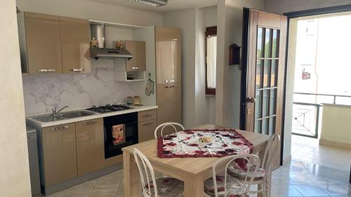 龙基德伊莱焦纳里Rose e Frutta ristrutturato con parcheggio的厨房配有桌子、水槽和炉灶。