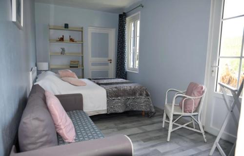 卢昂Gîte chez Madeleine的一间卧室配有一张床、一张沙发和一把椅子