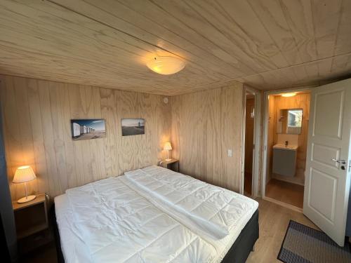 洛肯洛肯家庭露营地的一间带白色大床的卧室和一间浴室