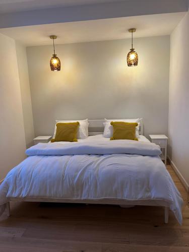 斯沃尼奇SeaViewApartment的卧室配有一张带黄色枕头的大型白色床。