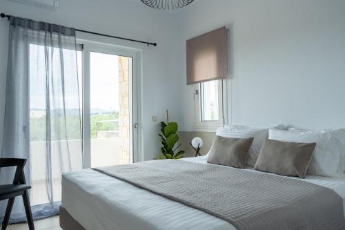 干尼亚Ros Solis Luxure House的白色的卧室设有一张大床和一个窗户