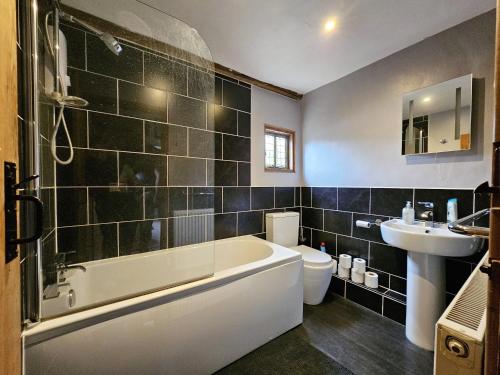 迪斯Perfectly Located Pretty Cottage的带浴缸、卫生间和盥洗盆的浴室