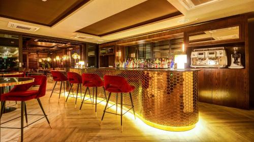 圣地亚哥Hotel Nodo - Primer hotel explorador urbano的餐厅内的酒吧,带红色椅子