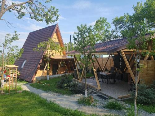 TaleaCiubar și Sauna SPA la Cabana de Vis Valea Prahovei的房屋设有倾斜的屋顶和庭院