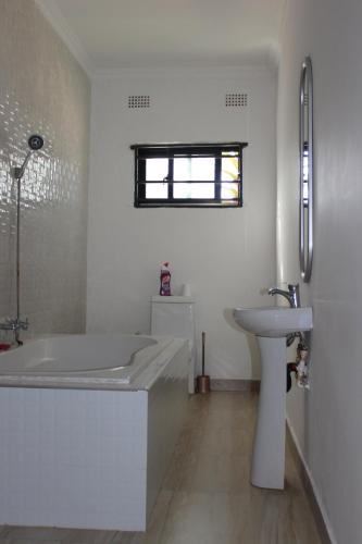 卢萨卡Blue Agave MH的白色的浴室设有浴缸和水槽。