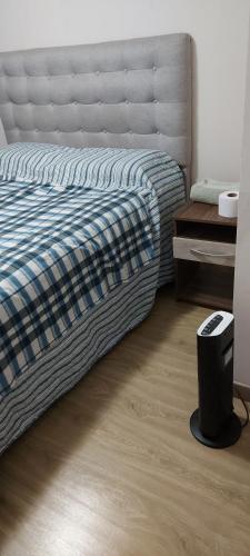 圣地亚哥habitacion Depto Business的一间卧室配有一张床,铺有木地板