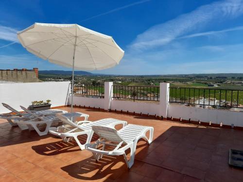 阿尔莫多瓦尔德尔里奥Lonja del Ribacillo, Casa Rural的庭院配有桌椅和遮阳伞。