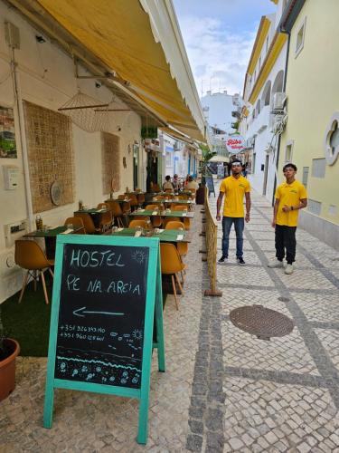 阿尔布费拉Residence Pé na Areia的几个男人在街上和一家餐馆散步