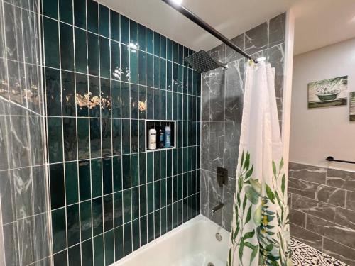 希尔顿黑德岛Tranquility in paradise- 2 bedroom villa w/parking的浴室配有绿色瓷砖墙和浴缸。