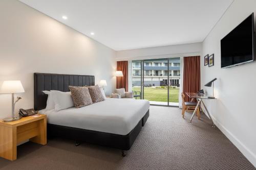 勒弗戴尔Rydges Resort Hunter Valley的一间酒店客房,配有一张床和一台电视