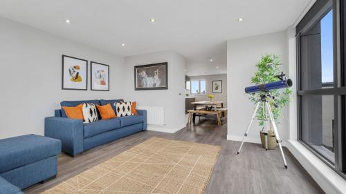 利物浦Host & Stay - The Baltic Penthouse 2的客厅配有蓝色的沙发和桌子