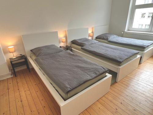汉诺威3 Betten Unterkunft Vahrenwald-List的配有两张床铺的房间,桌子上放着两盏灯