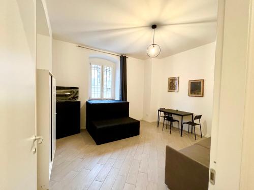 都灵Casa Genova 1/2/3的客厅配有黑色沙发和桌子