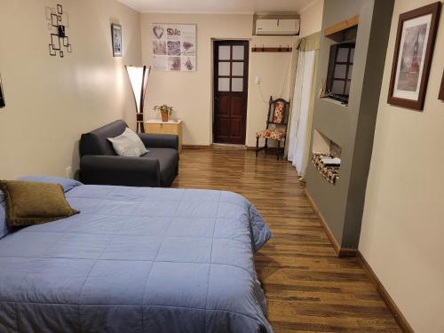 圣罗莎Monoambiente amplio, Centrico的一间卧室配有一张床、一张沙发和一把椅子