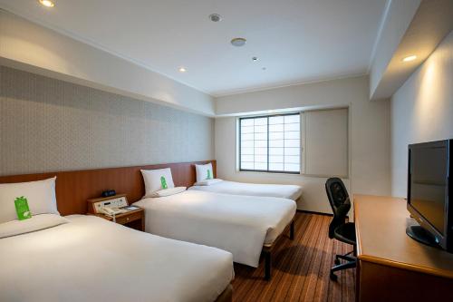成田成田国际花园酒店的酒店客房设有两张床和一台平面电视。