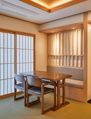 南海郡Tomonoya Signature Ryokan Namhae的一间带木桌和椅子的用餐室