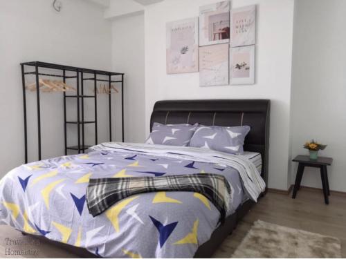 实兆远[FREE WI-FI]Travelers Homestay Sitiawan[6~10Pax]The Venus Apartment的一间卧室配有一张带紫色和黄色棉被的床