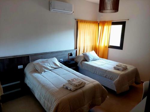 乌尼翁镇Casa - del TALAMPAYA的酒店客房设有两张床和窗户。