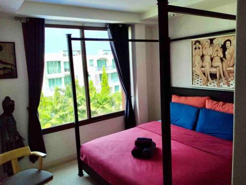 考陶Las Tortugas, Cozy condominium on Khao Tao beach, Hua Hin的一间卧室设有红色的床和窗户。