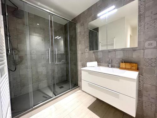 卢加诺Lakeside Attic的带淋浴、盥洗盆和镜子的浴室