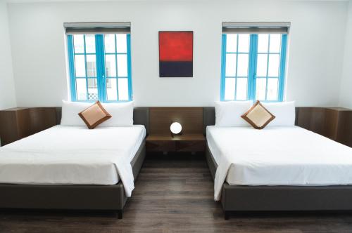 下龙湾Luxury Homestay Sun Feria Ha Long的带2扇窗户的客房内的2张床