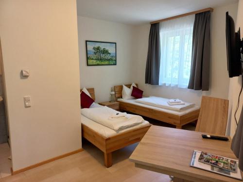 SaxenGasthof Sturmmühle的酒店客房设有两张床和一张桌子。