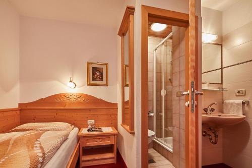 科尔福索Garni Reutlingen的一间卧室配有一张床、淋浴和盥洗盆