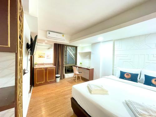 曼谷WellQuest Wellness Ladprao Soi 1的配有一张床和一张书桌的酒店客房