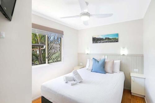 坦卡里Reflections Tuncurry - Holiday Park的卧室配有带蓝色枕头的大型白色床