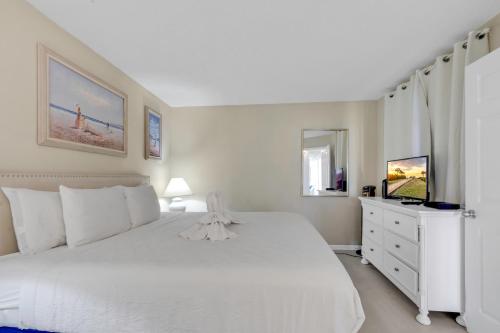 默特尔比奇Hosteeva Beach View 1BR Ocean Forest Plaza Condo的白色卧室配有白色的床和梳妆台