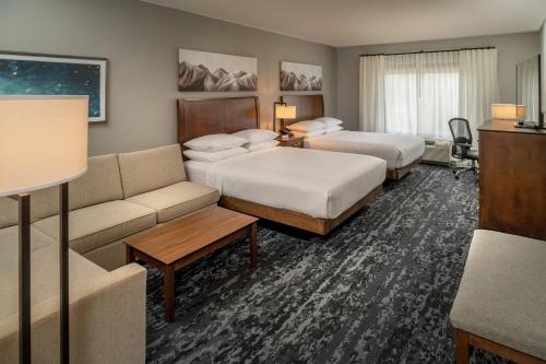 巴伯斯维尔Delta Hotels by Marriott Huntington Mall的酒店客房,设有两张床和一张沙发