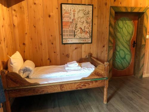 沃戈穆Vågåvatnet Feriesenter的一张小床,位于带绘画的木房内