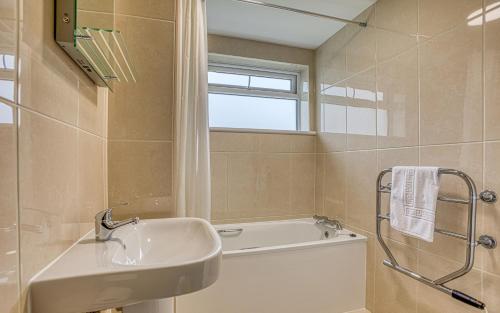 圣彼得港Ilex Lodge的浴室配有盥洗盆和浴缸。